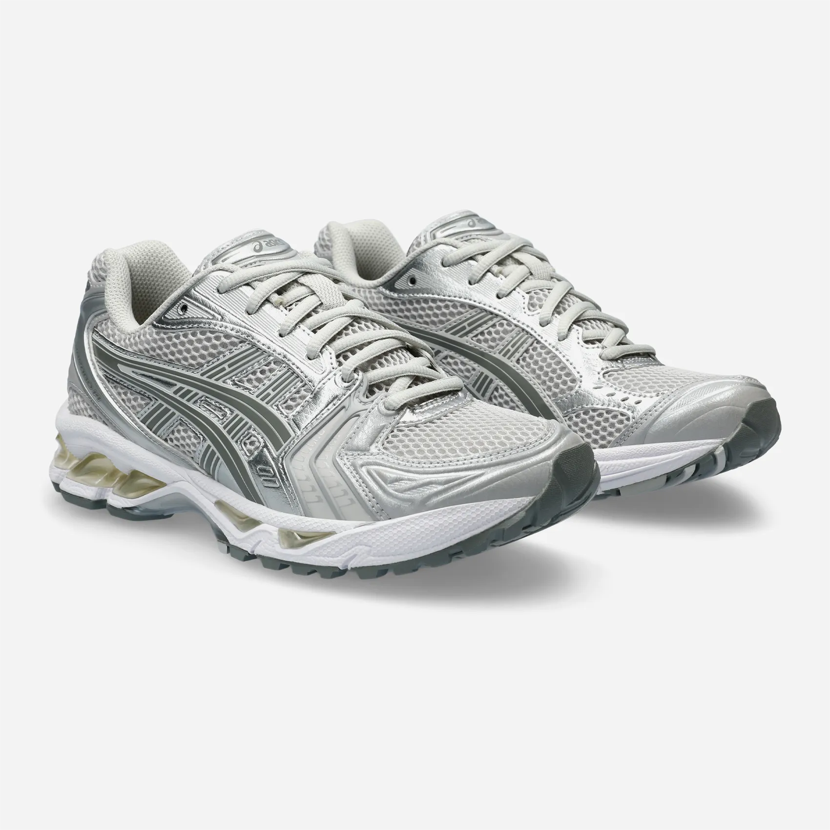 Vue trois-quarts avant ASICS Kayano 14 montrant le mesh gris et cuir argent.