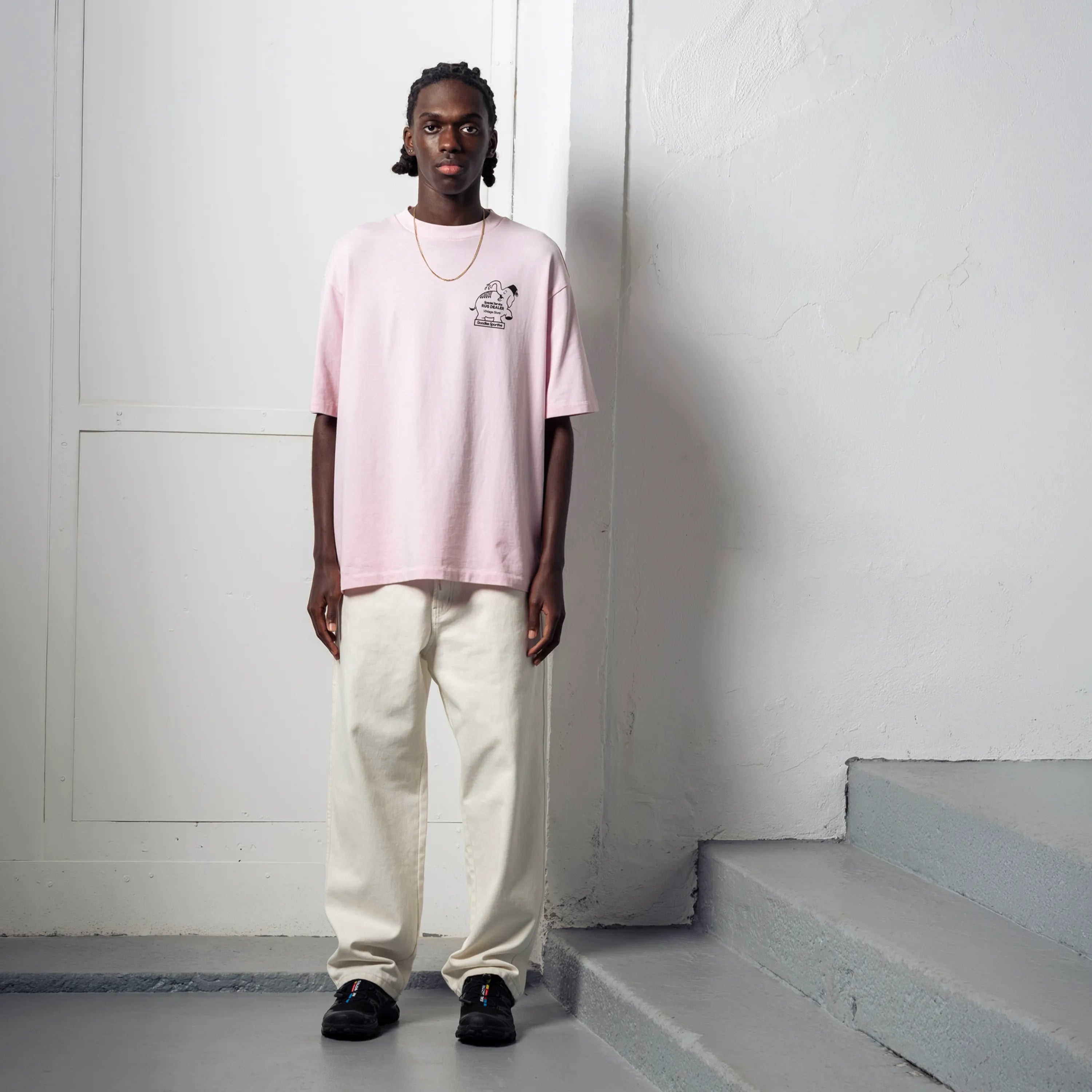 Look streetwear homme avec t-shirt rose Goodies Sportive et pantalon blanc.