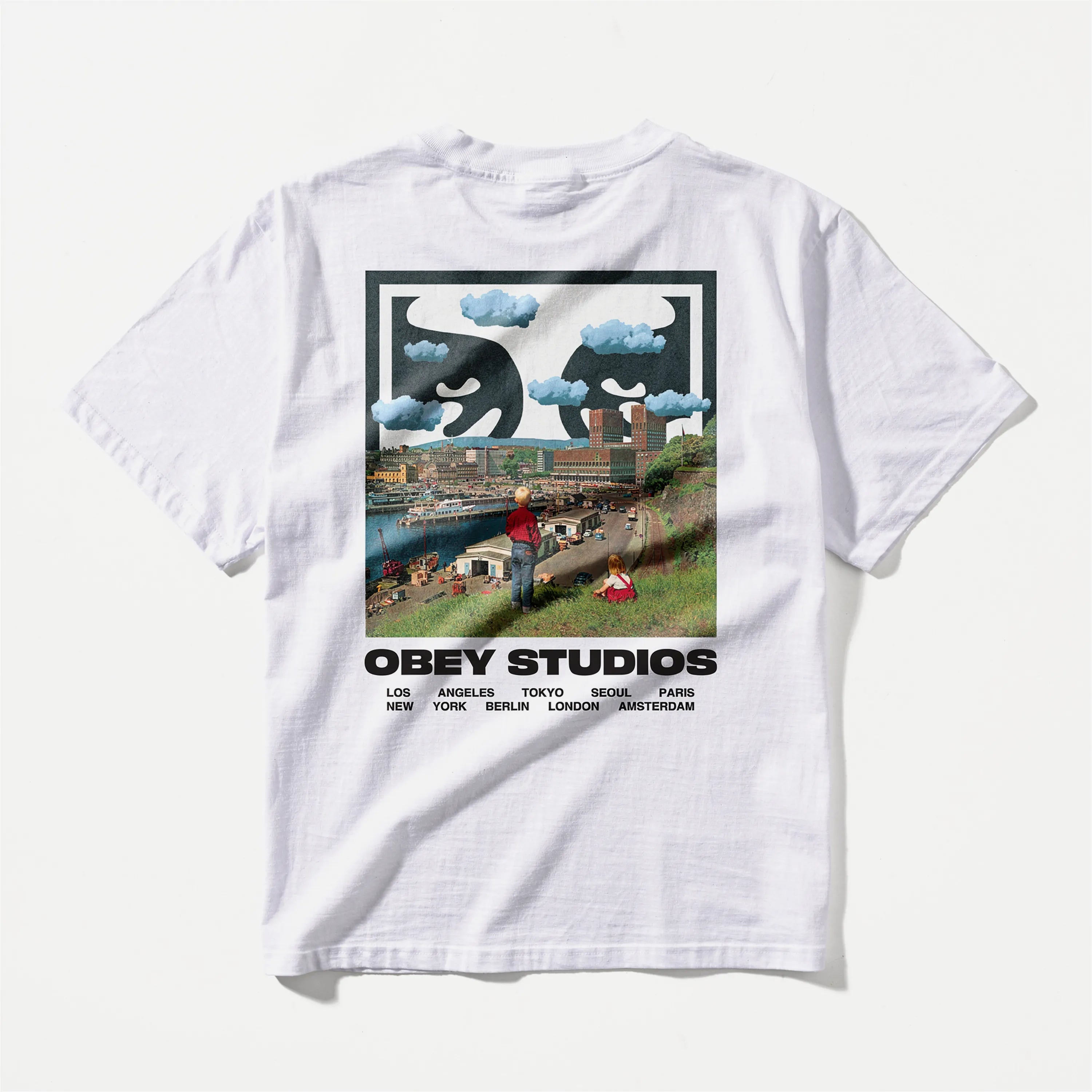 Dos du t-shirt Obey blanc en coton lourd montrant un grand collage graphique d'une ville et d'un visage dans le ciel.
