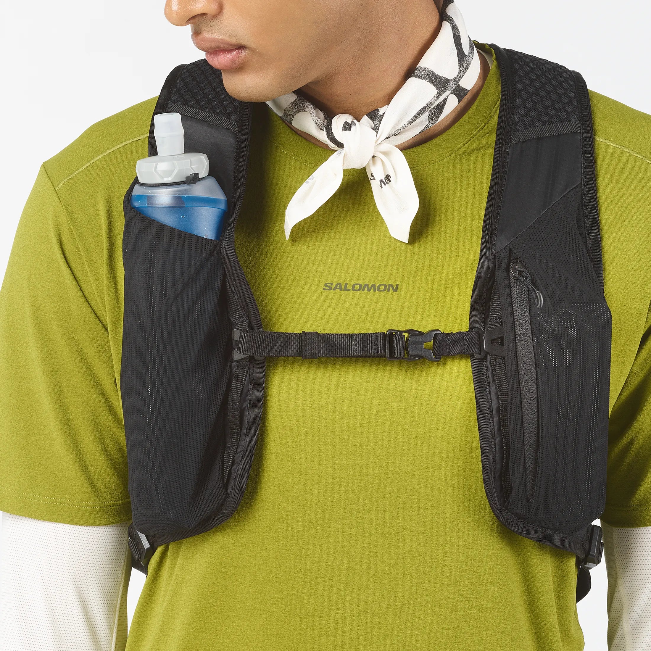 Homme portant le sac Salomon XT 25 avec flasque d'eau sur la bretelle.