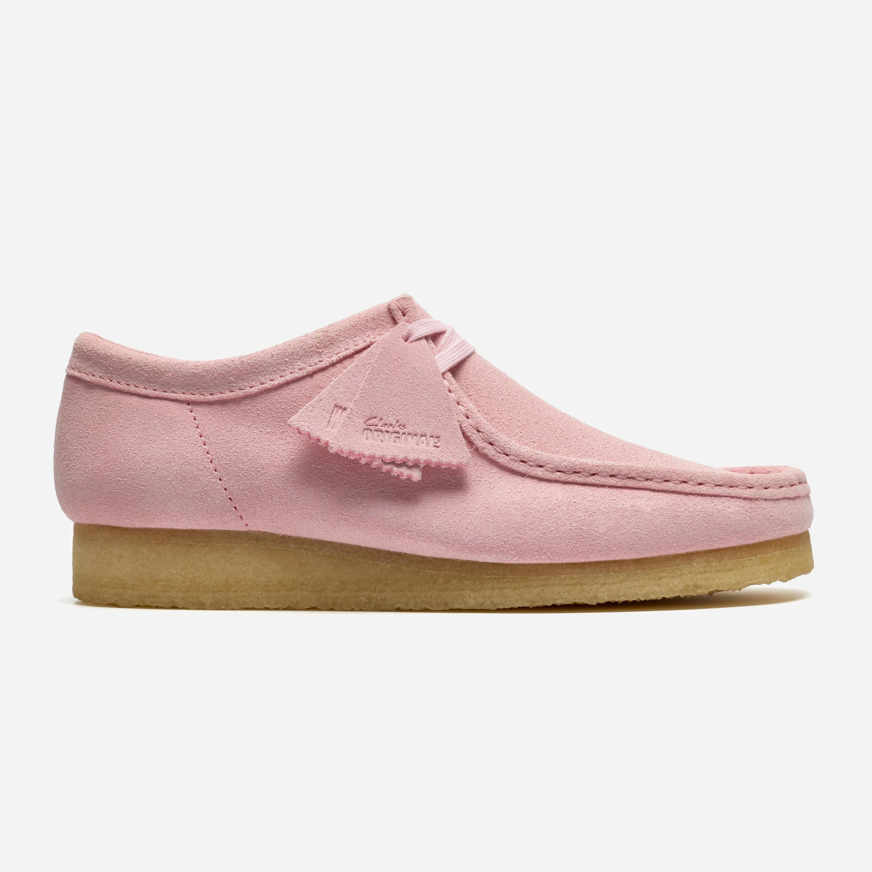 Profil extérieur de la mythique chaussure Clarks Wallabee en daim rose pastel avec semelle en crêpe naturel et étiquette fob.