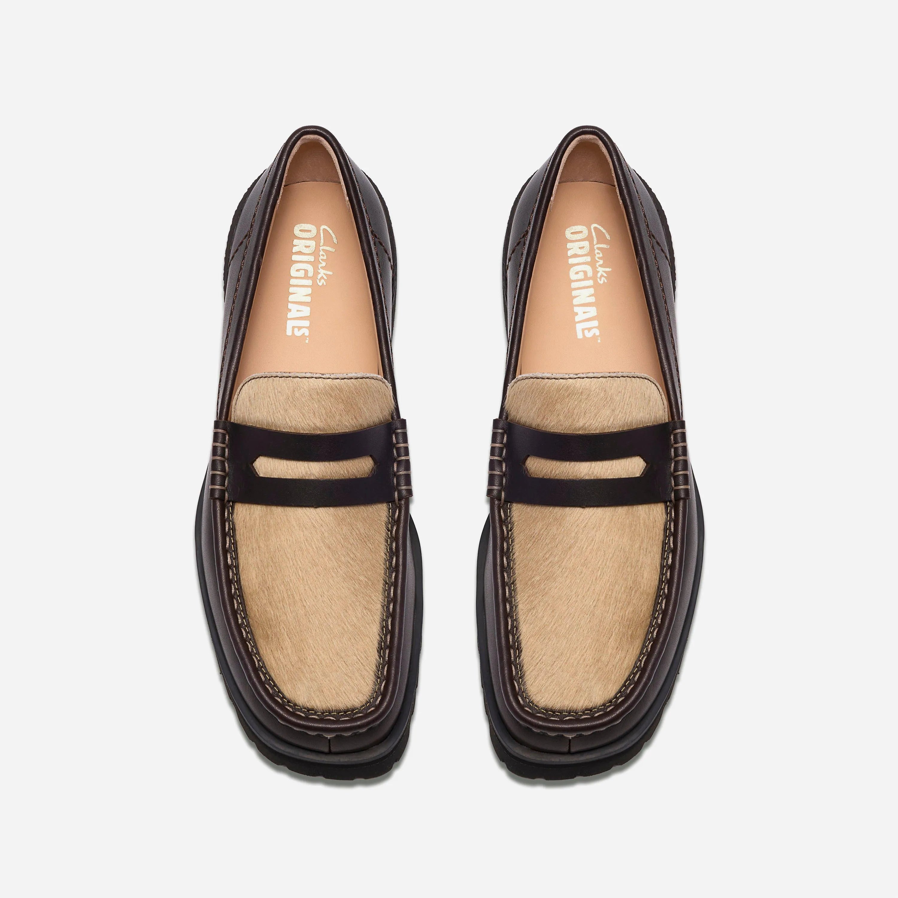 Vue de dessus des chaussures Clarks montrant le plateau hair-on contrastant, la bride penny et la semelle intérieure en cuir premium.