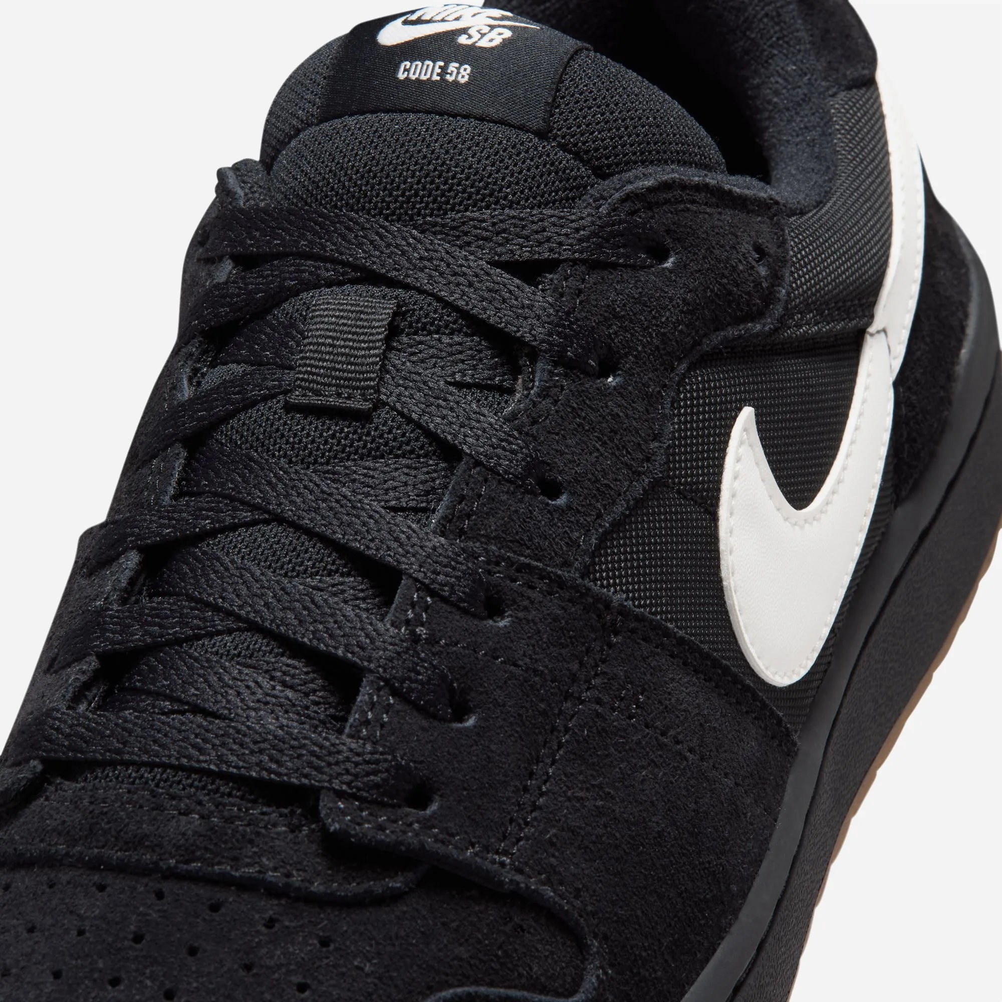 Close-up of Summit White Swoosh and black suede upper on Nike SB Code 58