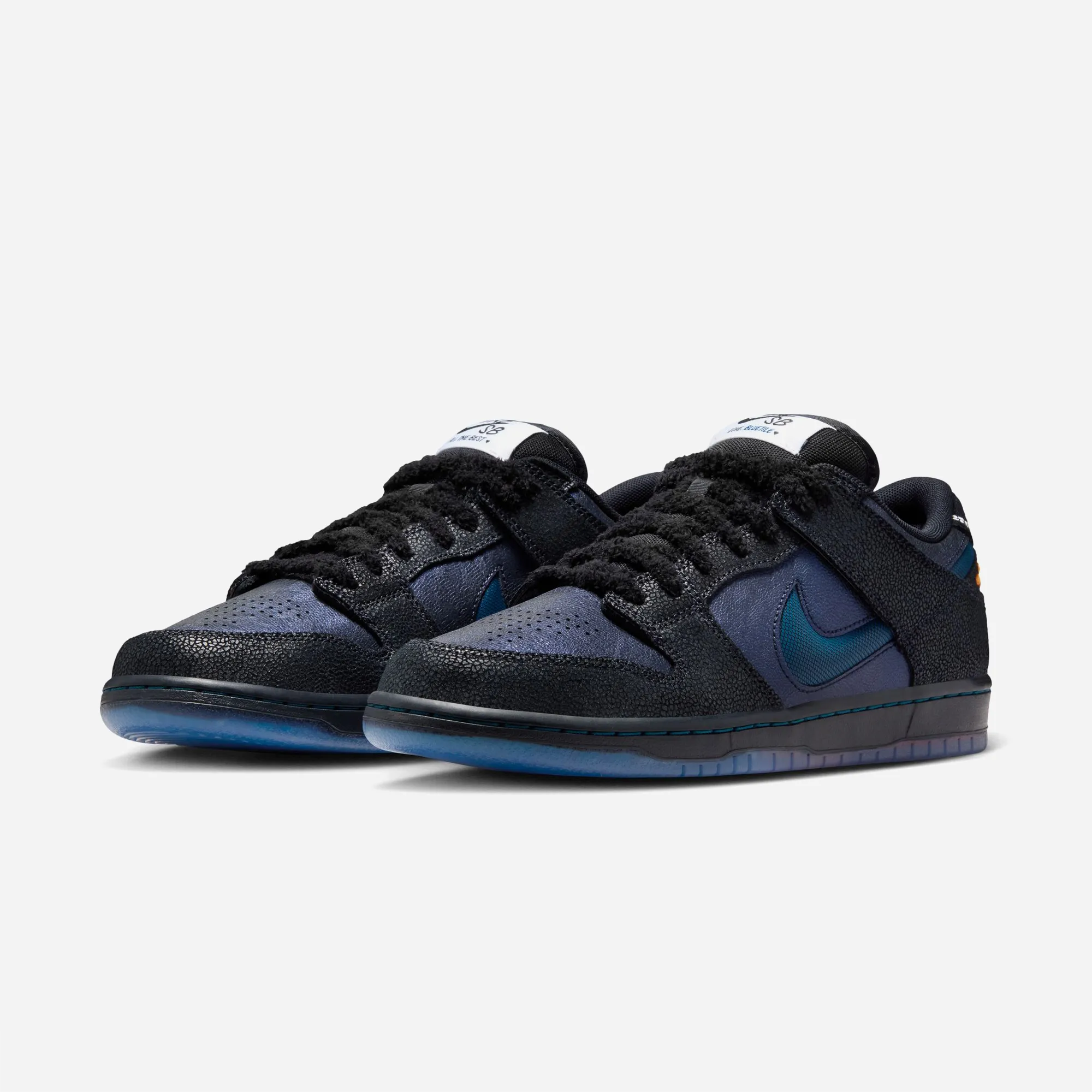 Nike SB Dunk Low Bluetile portée de trois quarts, lacets chenille noirs, branding languette Nike SB Love Bluetile, chaussure skate collab Caroline du Sud monarque