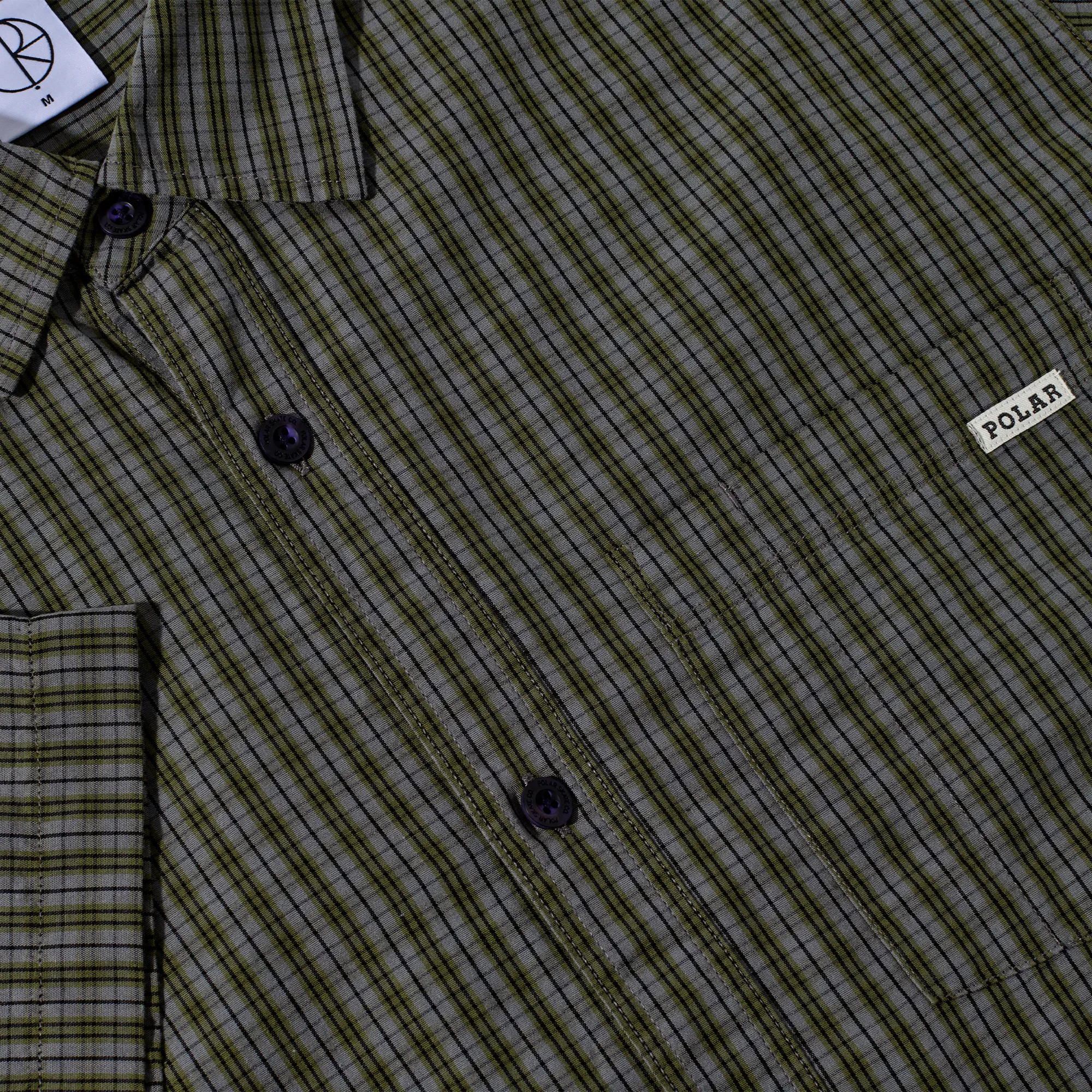 Détail de la poche poitrine et de l'étiquette tissée sur la chemise loose fit Polar Skate Co.