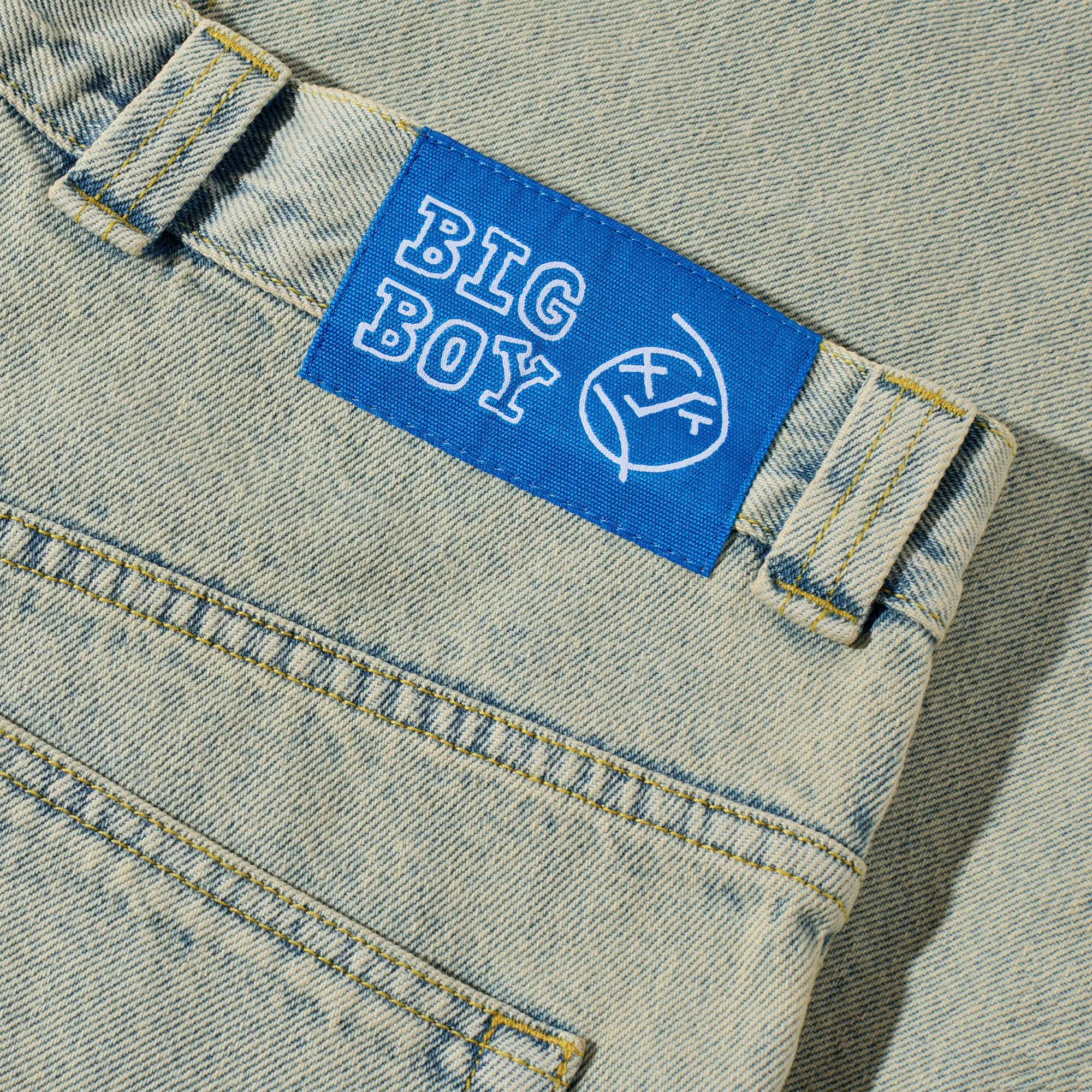 Detail of the blue woven waist label on the baggy Polar Skate Co Big Boy streetwear jeans.