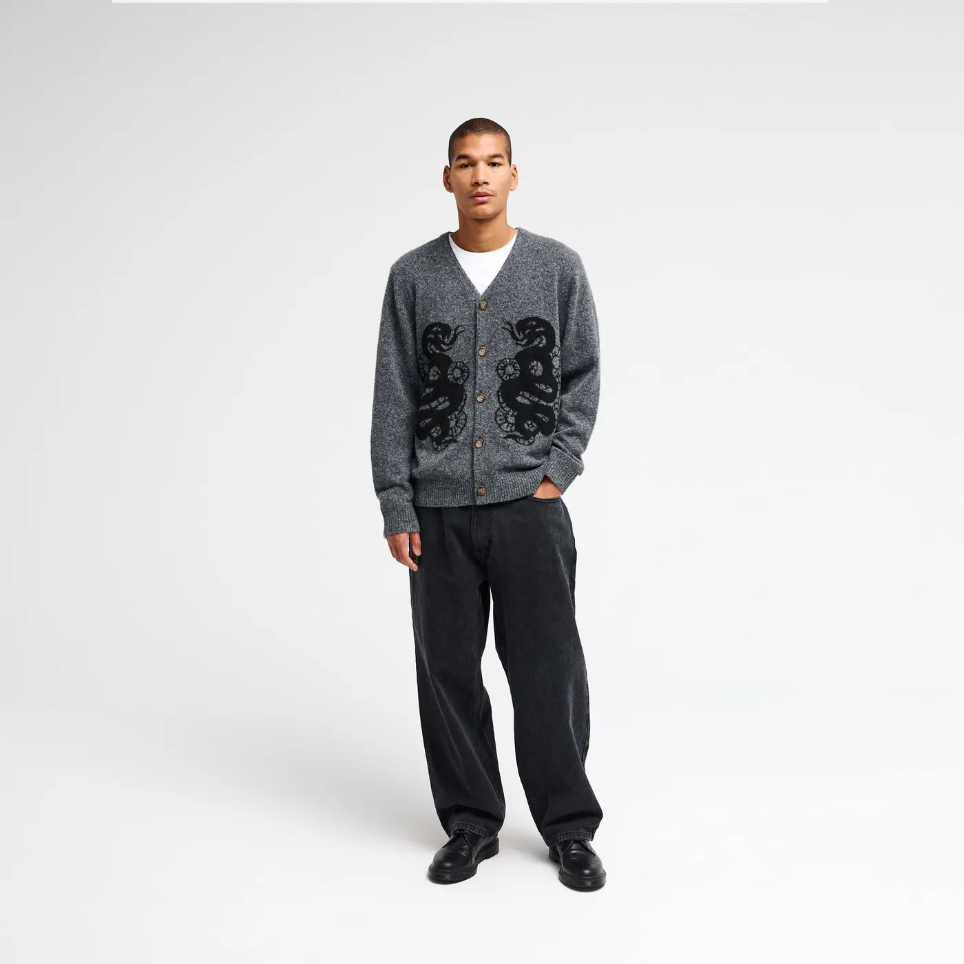 Cardigan RVCA Dalas Snake porté sur t-shirt blanc et pantalon noir.