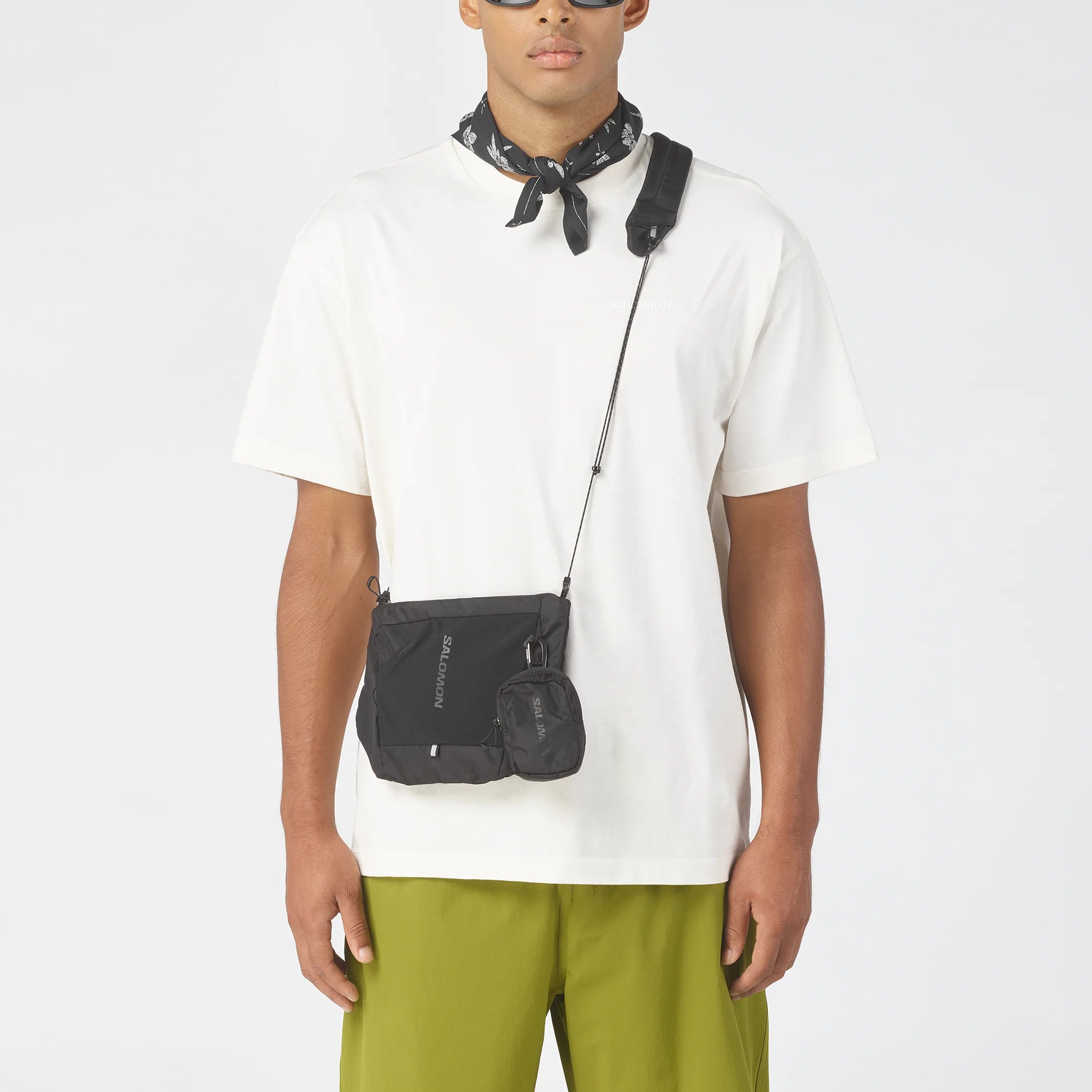 Homme portant la sacoche Salomon ACS 2 noire sur t-shirt blanc.