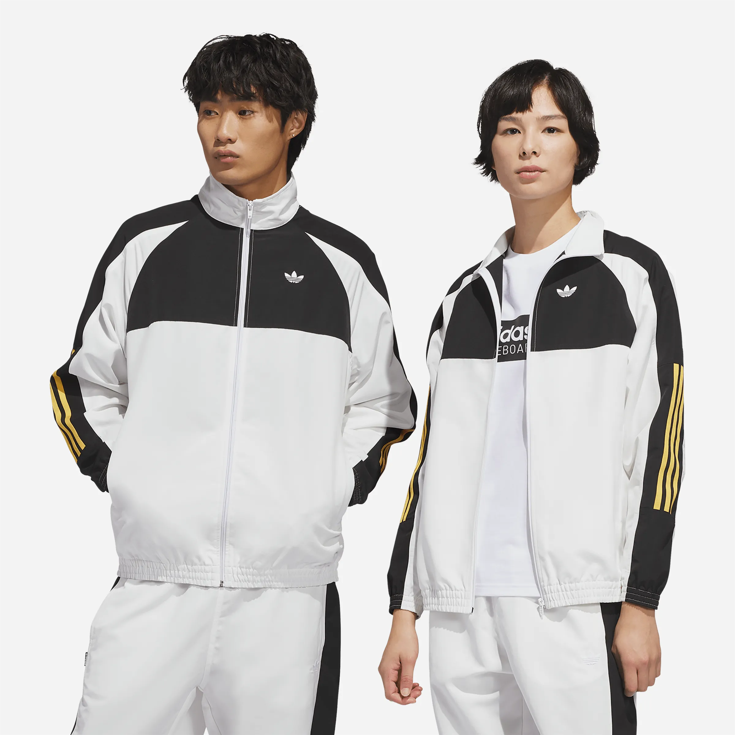 Couple portant l'ensemble de survêtement Adidas Gatsele blanc et noir.