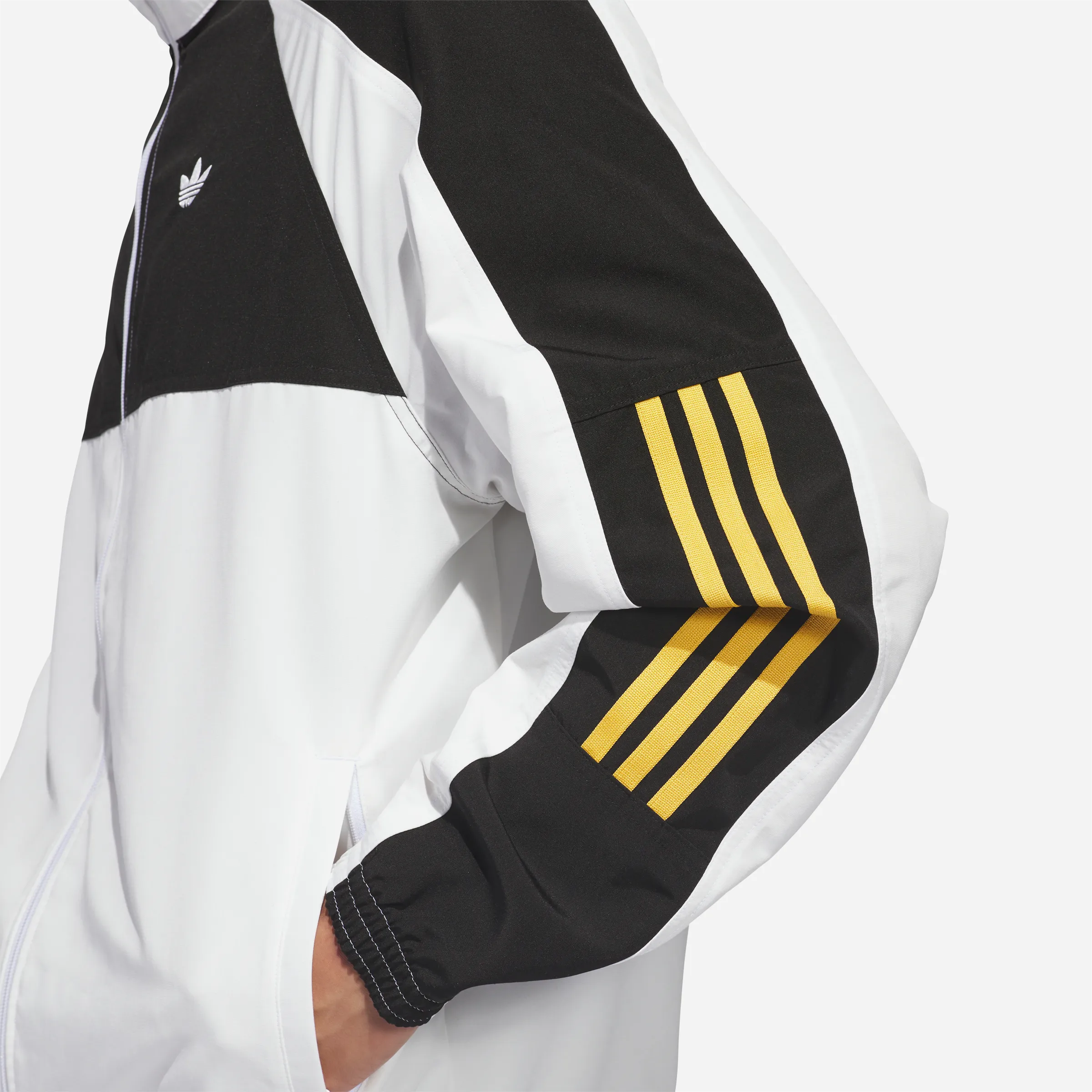 Gros plan sur les trois bandes Adidas jaunes sur manche noire.
