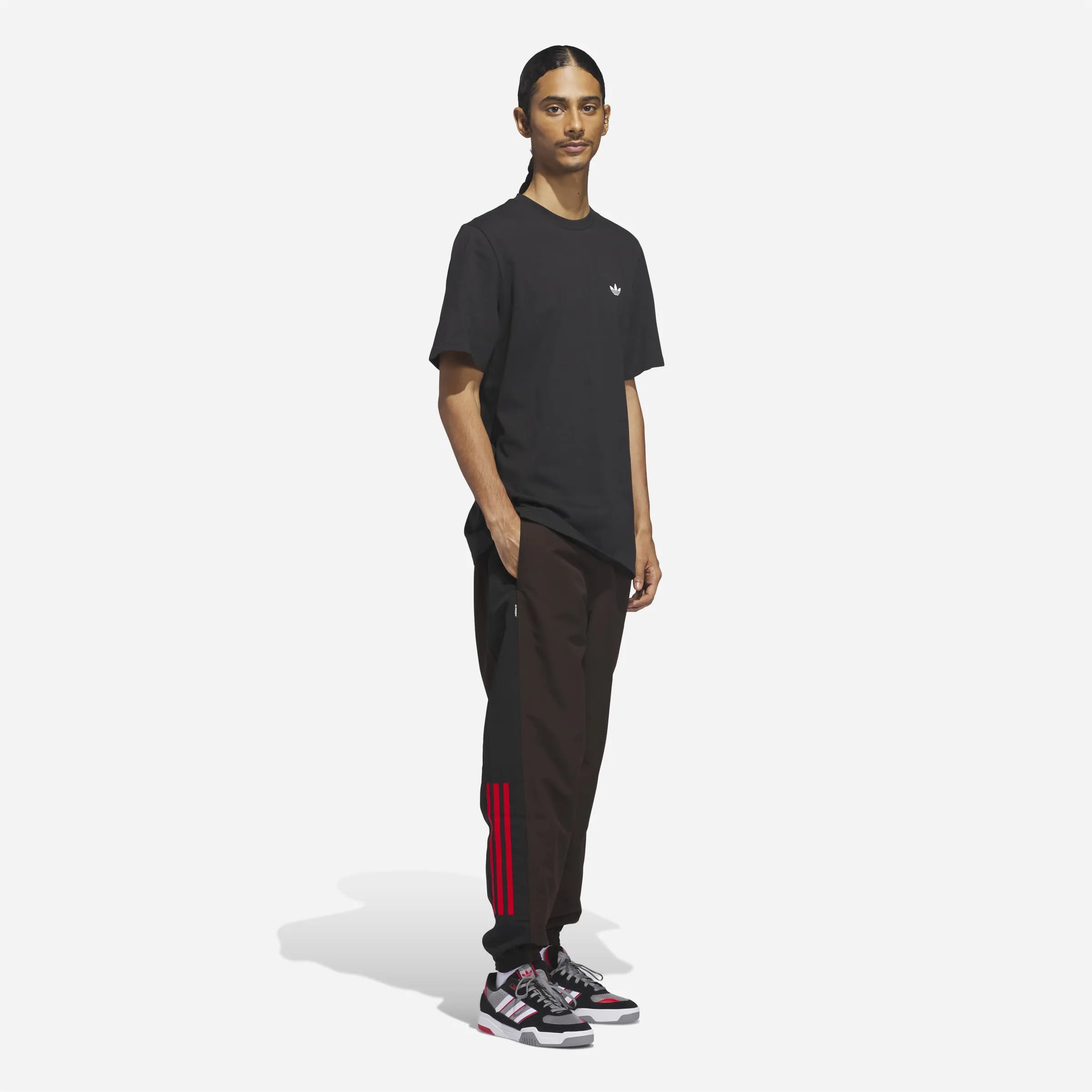 Man wearing the loose fit Adidas Gatsele Aurora Coffee pants.