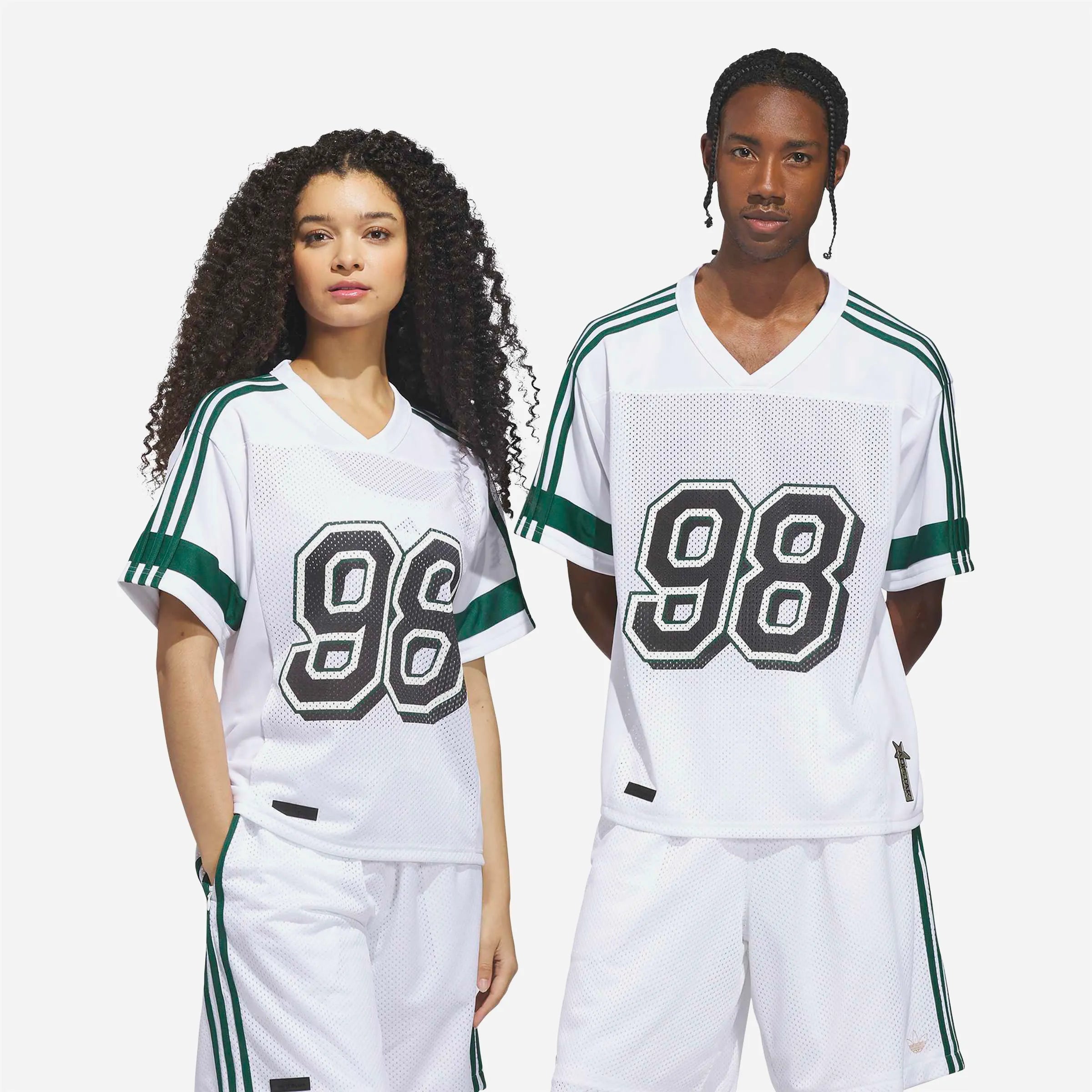 Couple portant le maillot Adidas Tyshawn blanc et vert style unisexe.