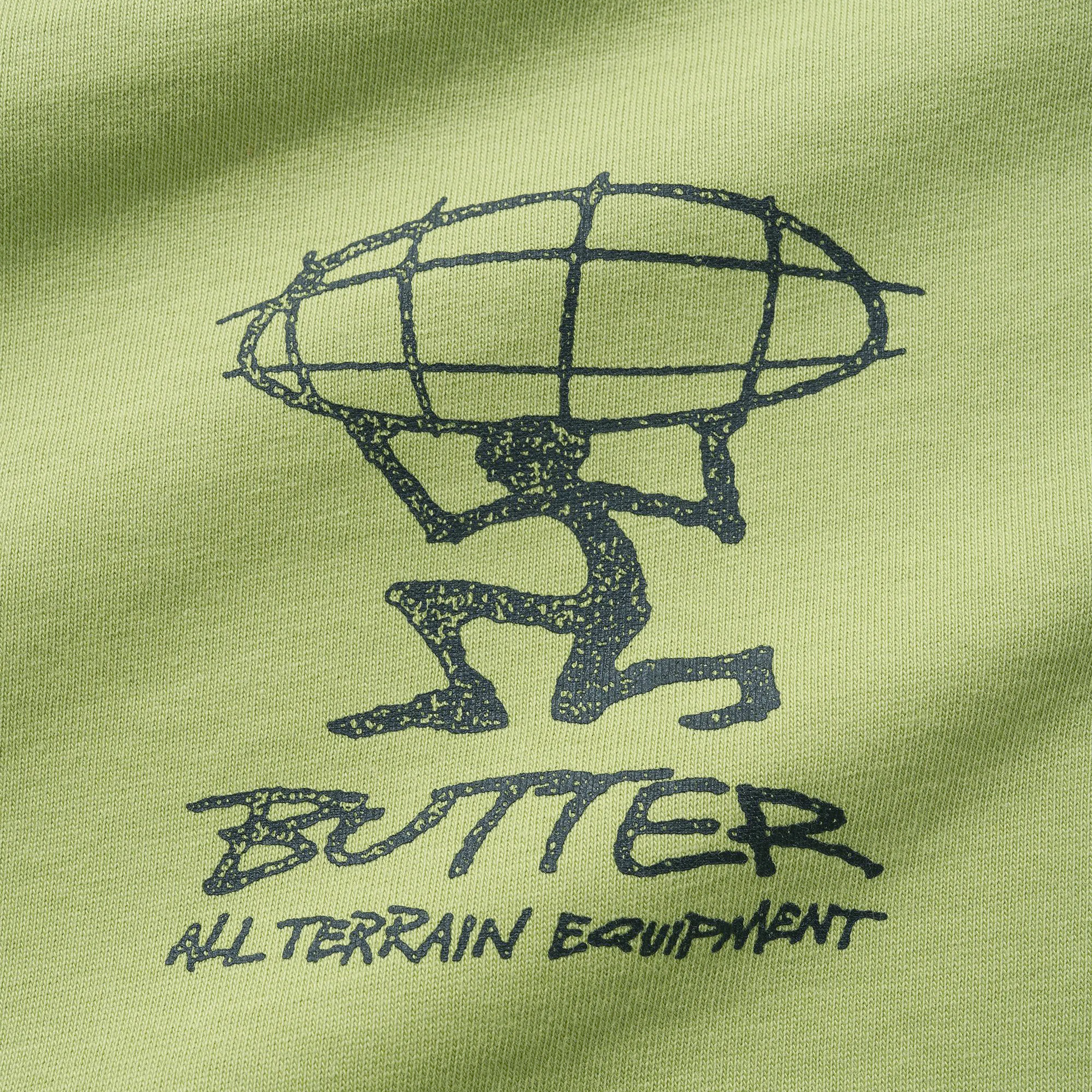 Close up on the textured screen print of the Butter Goods t-shirt showing the hand-drawn All Terrain Equipment logo.