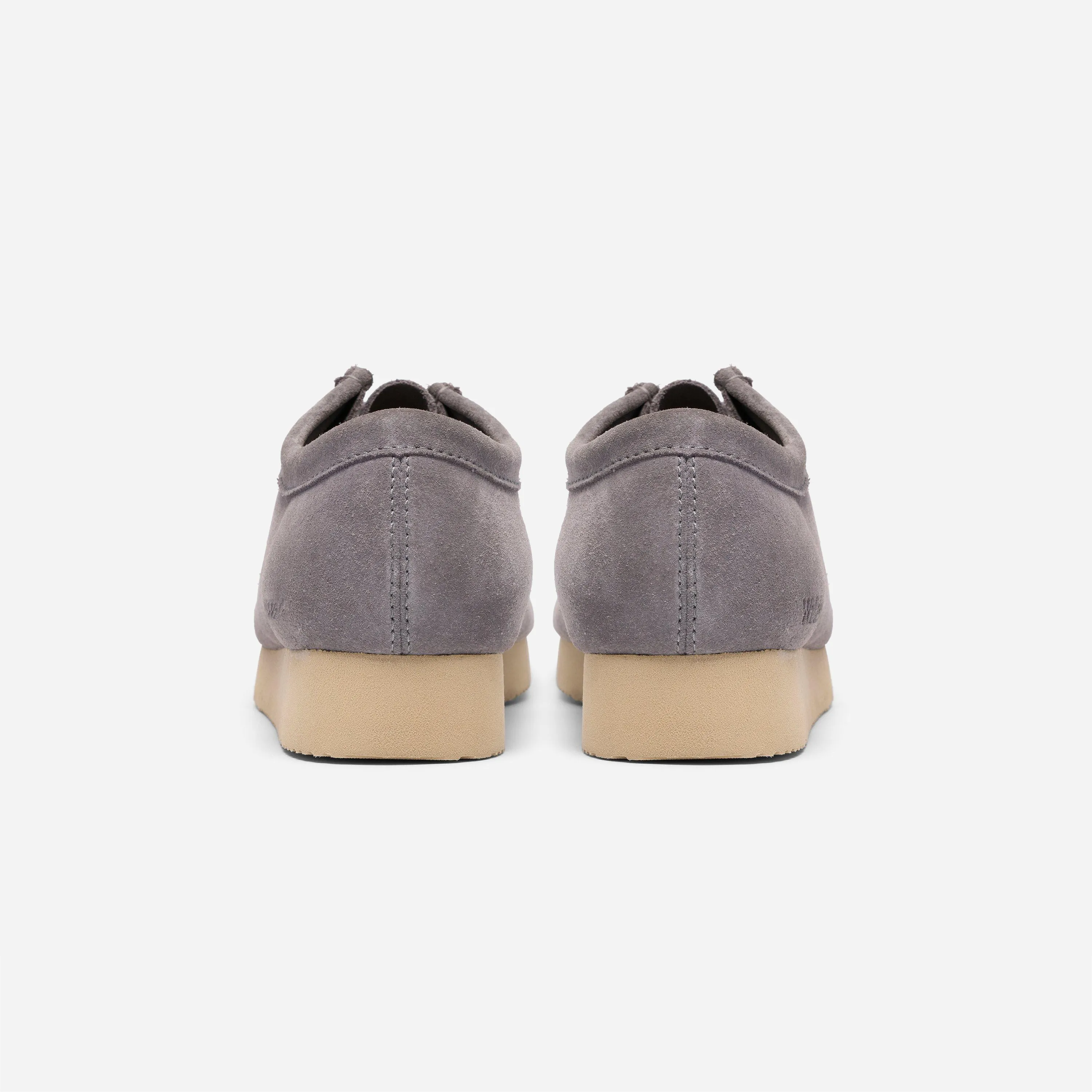 Vue arrière des mocassins Clarks Wallabee gris montrant les coutures de la tige sur la semelle épaisse épaisse.