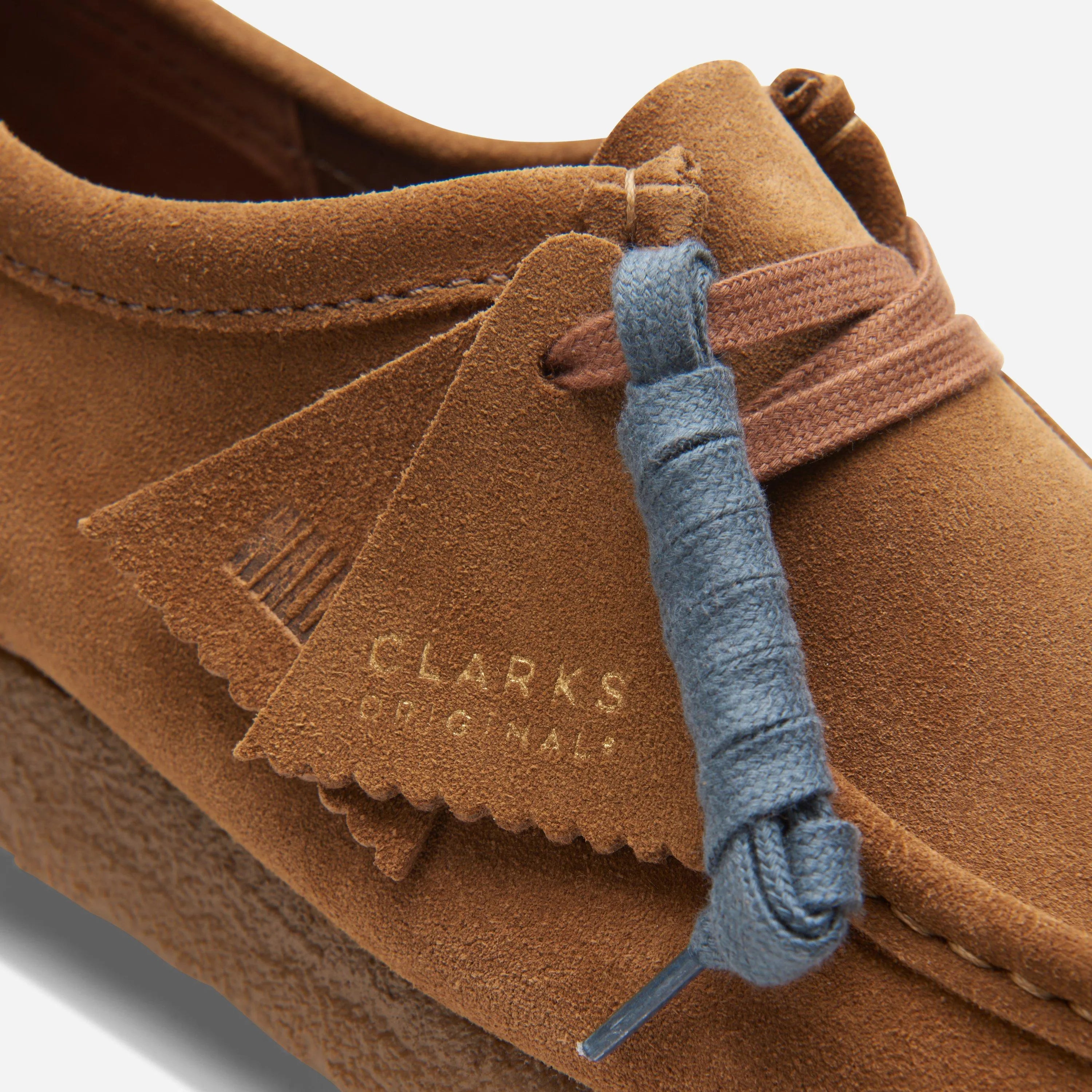 Close up on the waxed laces, premium suede texture, and the two tonal Clarks Originals fobs.