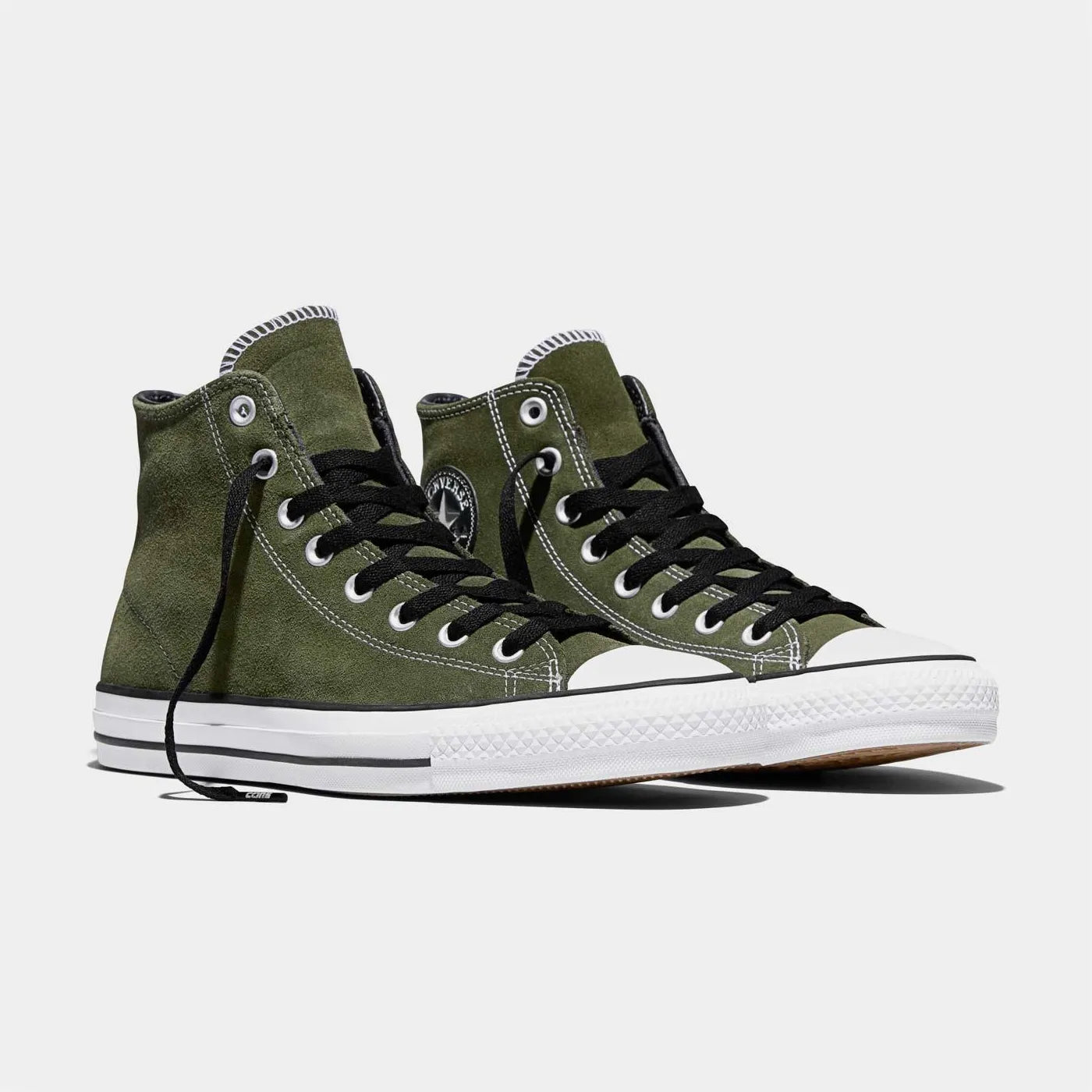 Chaussures de skate montantes Converse Cons vertes en daim avec lacets noirs.