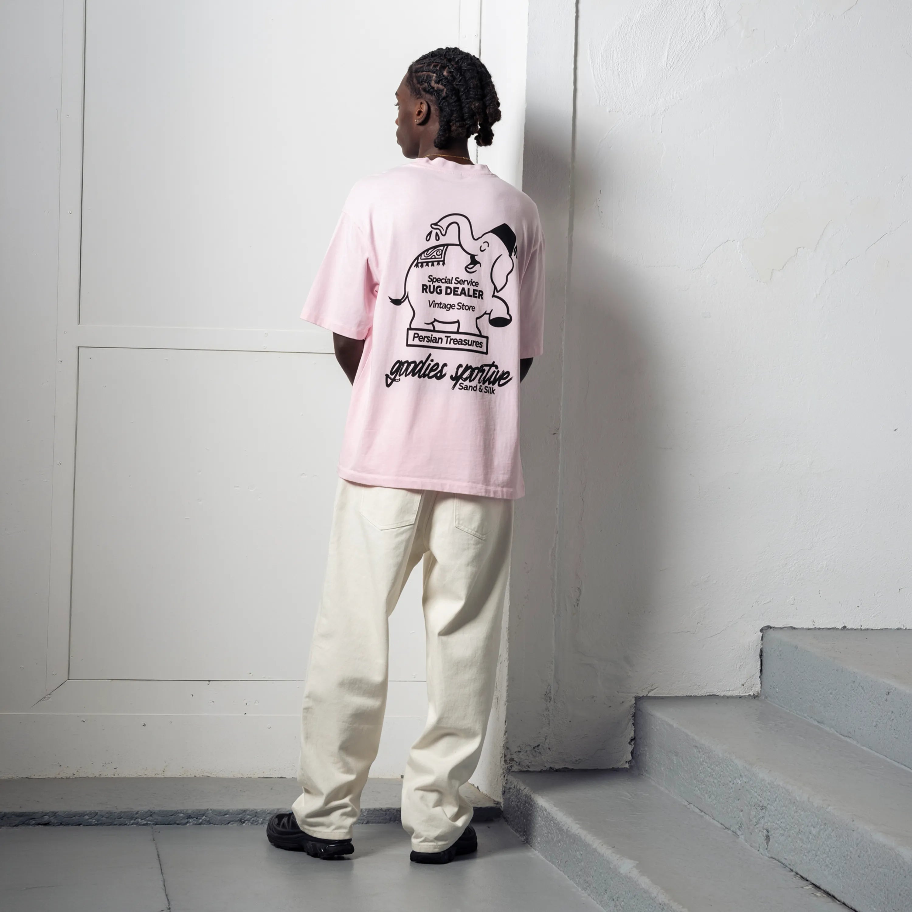 Back view of a man wearing the Goodies Sportive Persian Treasures T-shirt.
