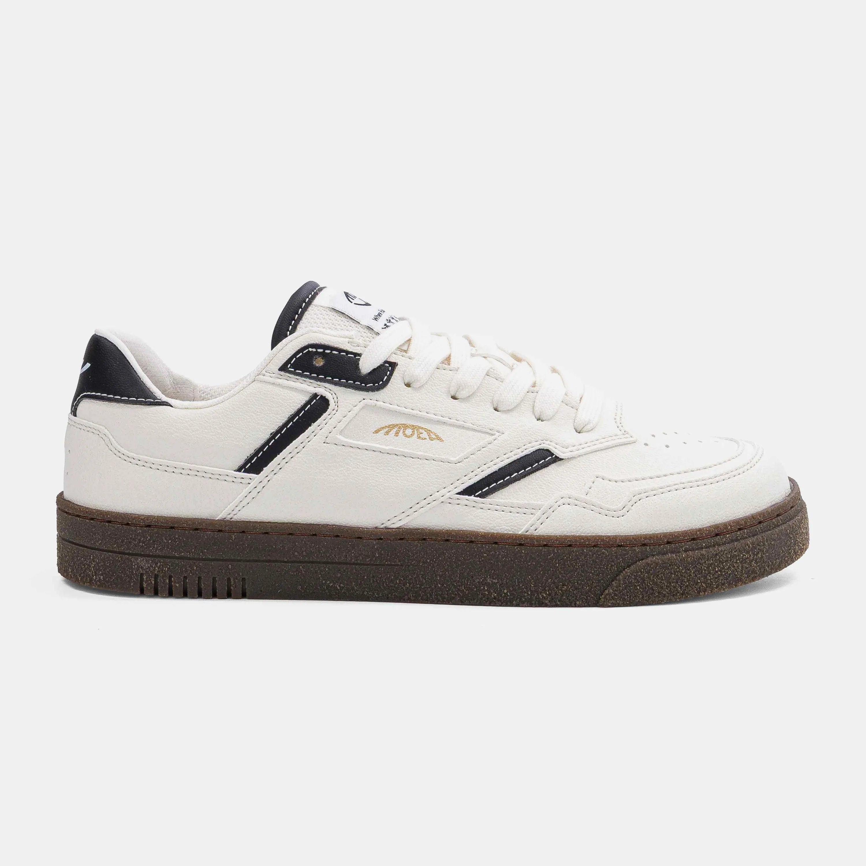 Vue de profil des baskets MoEa Origin Low Corn Black and White avec semelle en gomme marron.