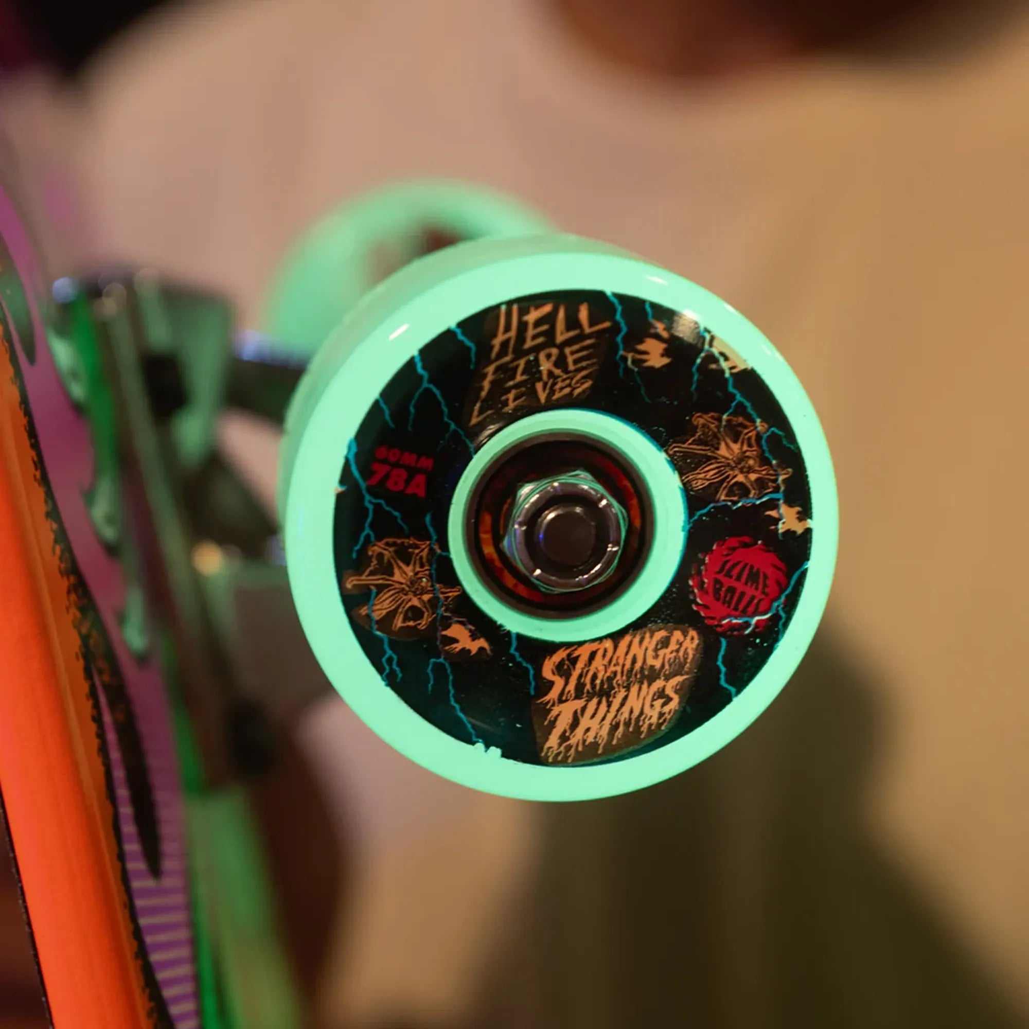 Slime Balls wheel that glows green in the dark mounted on a skateboard.