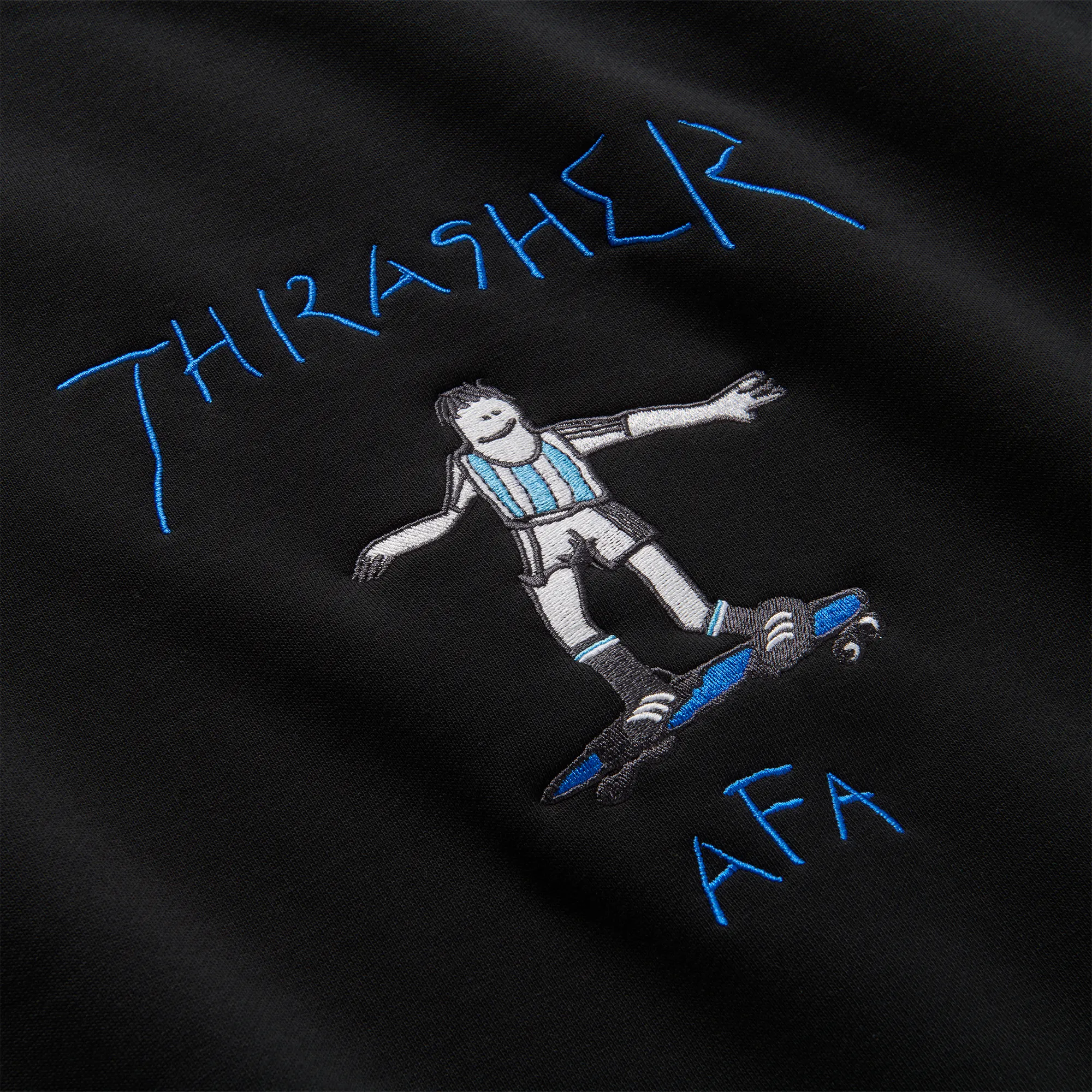 Détail de la broderie Thrasher et de l'illustration Gonz sur le crewneck Adidas noir.