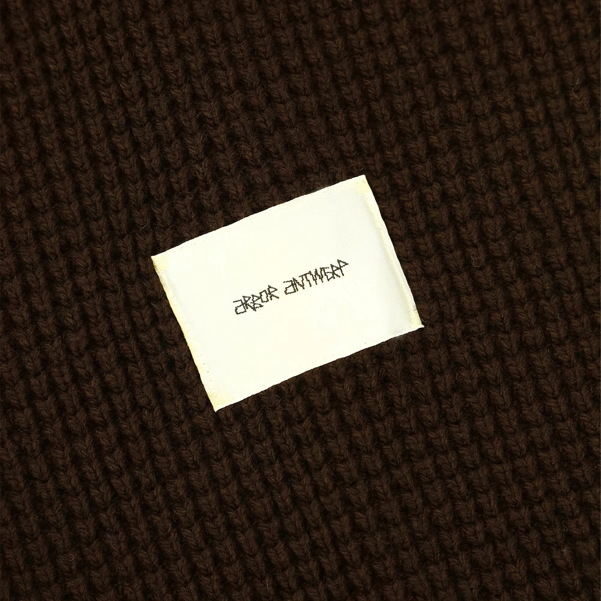 Close-up of the Arbor Antwerp sweater label and knit texture.