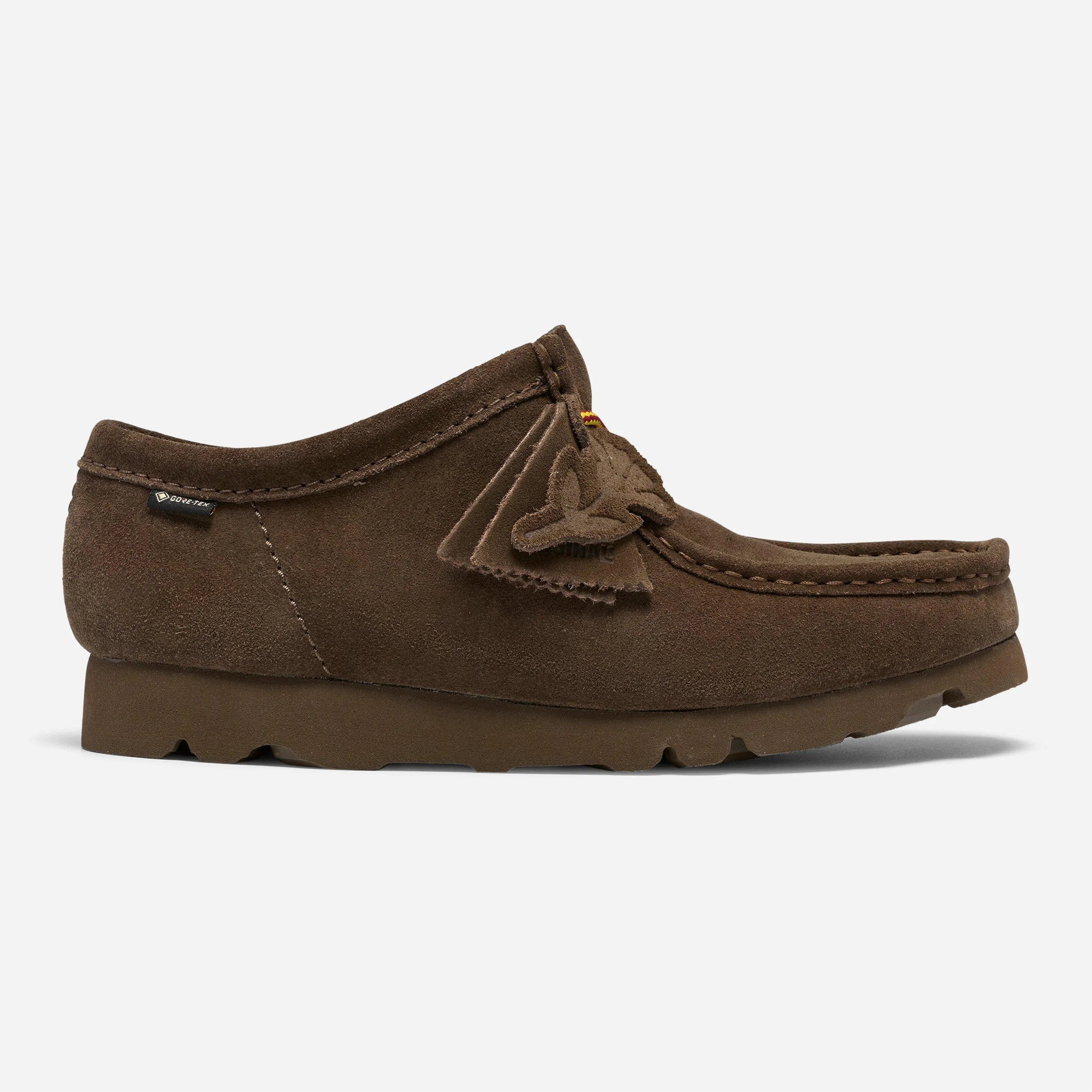 Clarks Originals Wallabee GTX daim olive foncé, vue de profil avec semelle Vibram et lacets tressés jaune et bordeaux