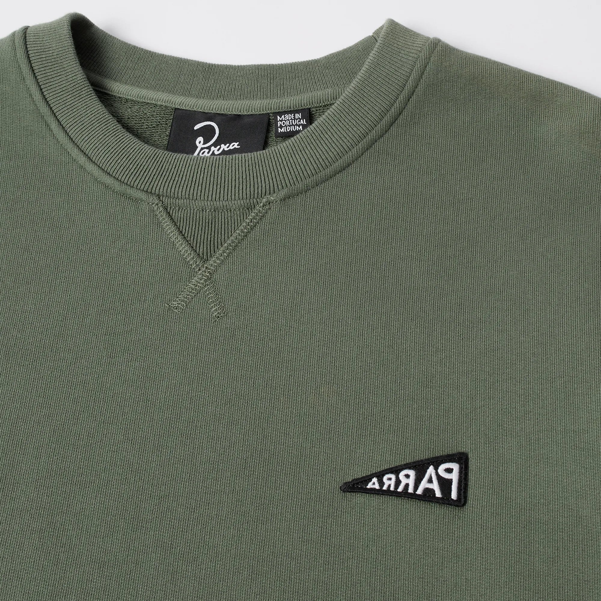 Close-up of the Parra logo embroidery on the green sweatshirt.