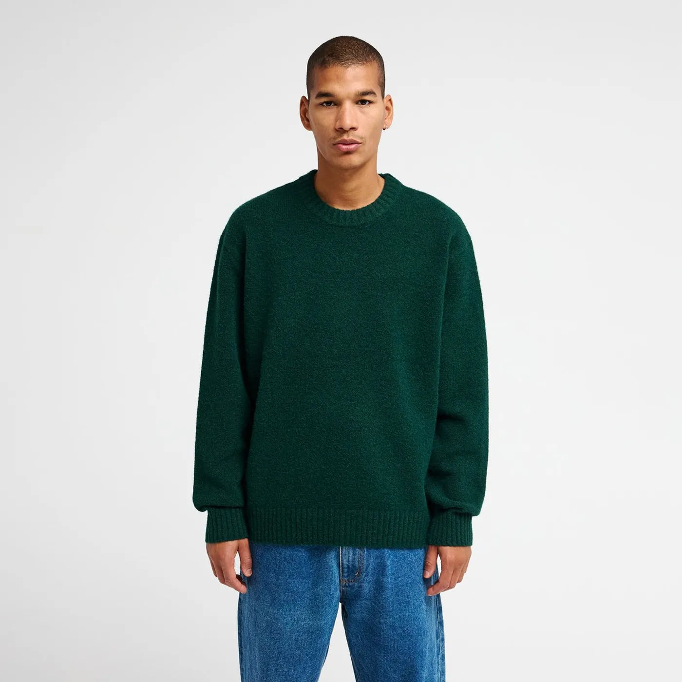 Pull col rond vert Hunter Green RVCA Ino Prep Solid porté avec un jean.