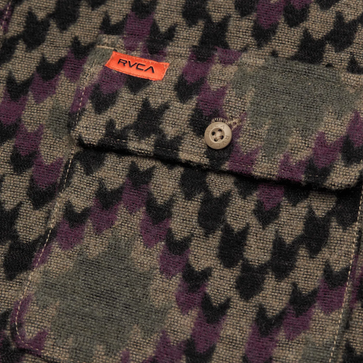 Gros plan sur la poche poitrine boutonnée et l'étiquette orange de la chemise RVCA Blanket Wood